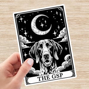 May include: Black and white sticker featuring a German Shorthaired Pointer dog with a crescent moon and stars in the background. The text "THE GSP" is at the bottom of the sticker.