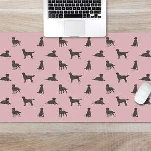 May include: A pink desk mat with a repeating pattern of black labrador silhouettes. A white computer mouse is on the mat.