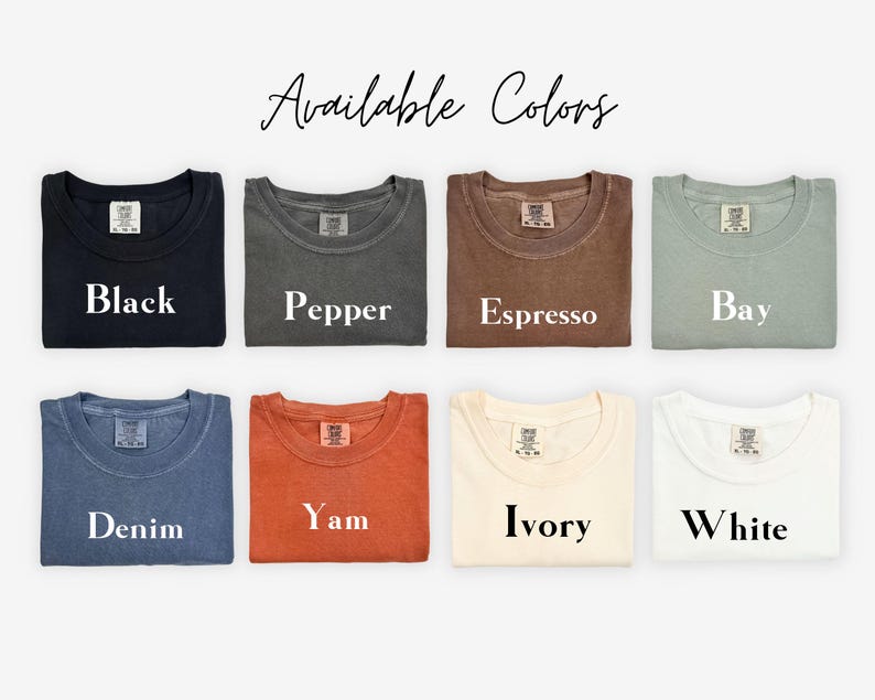 Puede incluir: Una selecci&oacute;n de camisetas dobladas en varios colores, incluyendo negro, pimienta, espresso, bah&iacute;a, mezclilla, &ntilde;ame, marfil y blanco. El texto "Available Colors" est&aacute; escrito en cursiva en la parte superior de la imagen.