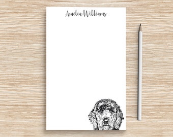 May include: A white notepad with the name "Amelia Williams" printed at the top. A black and white illustration of a dog's head is at the bottom of the notepad.