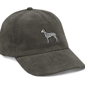 May include: A dark green corduroy baseball cap with an embroidered white and black Dalmatian dog on the front.