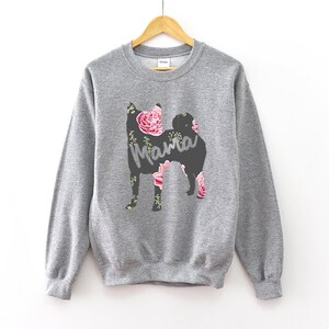 May include: Gray sweatshirt with a floral print of a dog silhouette and the word "Mama" in the center.