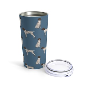 May include: A stainless steel tumbler with a blue background and a repeating pattern of German Shorthaired Pointer dogs. The tumbler has a clear lid.