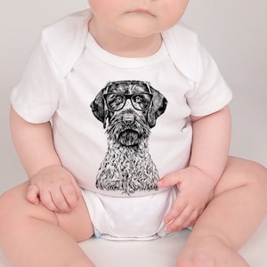 May include: A white baby onesie featuring a black and white illustration of a dog wearing glasses. The dog has a short, wiry coat and floppy ears.