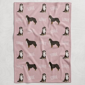 Puede incluir: Manta de franela rosa con un patr&oacute;n repetido de perros de monta&ntilde;a de Berna y el nombre "Sophie" impreso en ella.