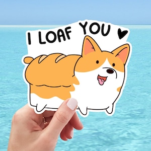 May include: A sticker featuring a cartoon corgi dog with a loaf of bread body. The text "I loaf you" is above the dog. The corgi is orange and white with a pink tongue. The background is a blue ocean.