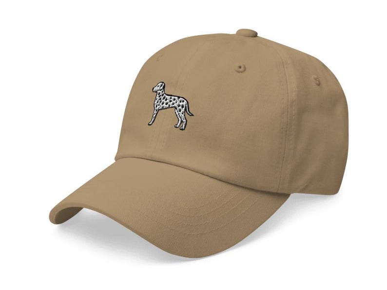 May include: A tan baseball cap with an embroidered black and white dalmatian dog on the front.