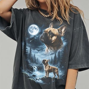 Peut inclure: T-shirt gris foncé avec un motif de bouledogue français. Le graphisme représente un chien dans une scène nocturne avec une pleine lune, une cascade et une forêt. Le t-shirt a des manches courtes et une coupe décontractée.