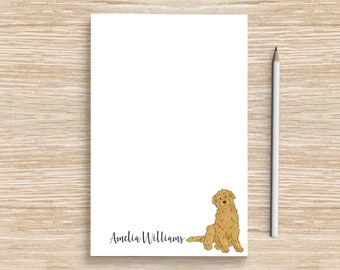 May include: A white notepad with a doodle of a golden doodle dog and the name "Amelia Williams" at the bottom.