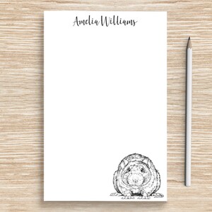 May include: A white notepad with the name "Amelia Williams" printed at the top. The notepad has a black and white illustration of a rat at the bottom.