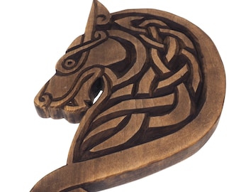 Peut inclure: Une sculpture en bois d'une tête de loup avec un motif complexe de nœuds celtiques. La sculpture est de couleur brun foncé et a une finition lisse.