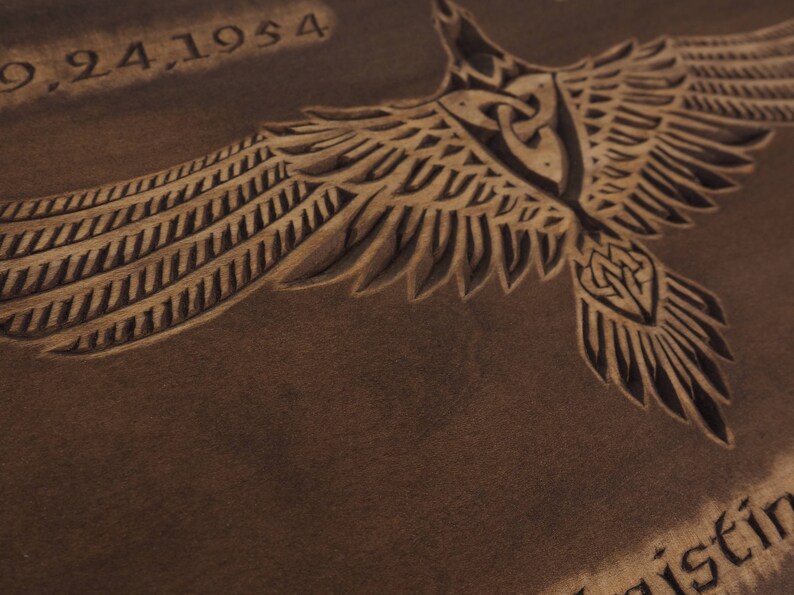 May include: A brown leather background with a carved design of a bird with outstretched wings. The date "9,24,1954" is carved at the top of the image. The word "geist" is partially visible at the bottom of the image.