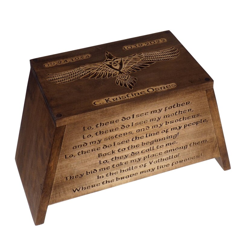 May include: A wooden box with a carved eagle design and the dates 09,94,1954 and 10,19,2022. The box is inscribed with the name C. Kristine Osnes and a poem about seeing family in the afterlife.