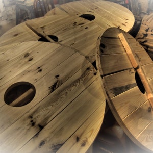 May include: Four wooden circular discs with a hole in the center. The discs are made of natural wood with a rustic finish.