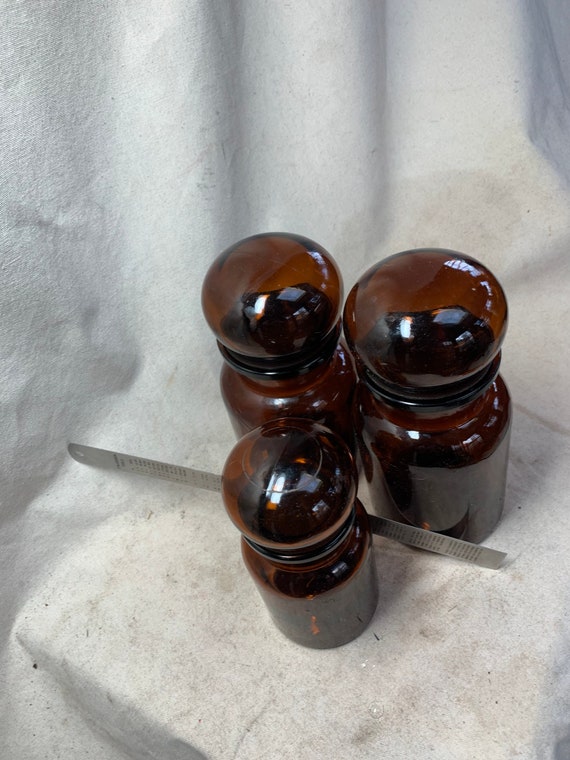 Three Covered Amber Canisters