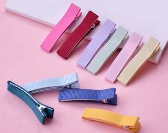 May include: Assortment of ten colorful hair clips with ribbon accents. The clips are in various colors, including pink, red, purple, green, blue, and yellow.