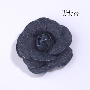 Puede incluir: Una flor de mezclilla azul oscuro con un dise&ntilde;o de p&eacute;talos en capas. La flor mide 7,4 cm de di&aacute;metro. La flor es un accesorio decorativo.