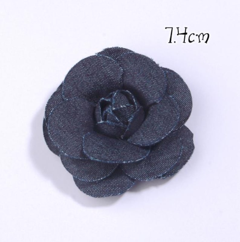 Puede incluir: Una flor de mezclilla azul oscuro con un dise&ntilde;o de p&eacute;talos en capas. La flor mide 7,4 cm de di&aacute;metro. La flor es un accesorio decorativo.
