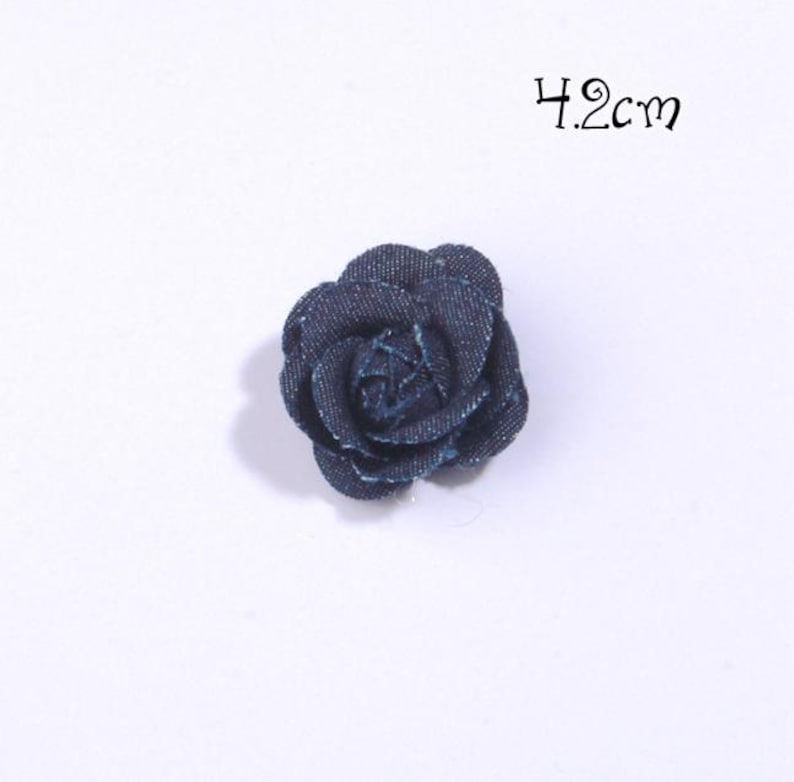 Puede incluir: Una flor de mezclilla azul oscuro, de aproximadamente 4,2 cm de di&aacute;metro, se muestra sobre un fondo blanco. La flor es un art&iacute;culo de artesan&iacute;a textil detallado, con el texto "4.2cm" en escritura negra encima.