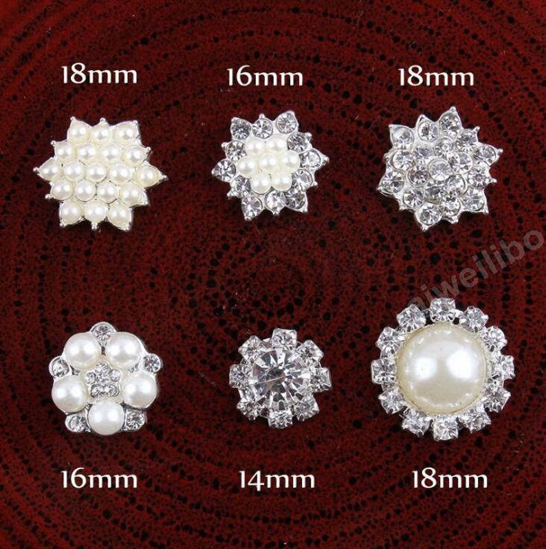 May include: Six silver-toned embellishments with pearl and rhinestone accents. The embellishments are arranged in two rows of three. The embellishments are 18mm, 16mm, 18mm, 16mm, 14mm, and 18mm in size.