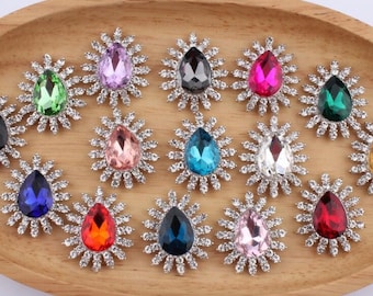 Puede incluir: Surtido de 12 adornos de cristal en forma de lágrima con engastes plateados. Cada adorno presenta un cristal en forma de lágrima rodeado por un diseño circular de cristales más pequeños.