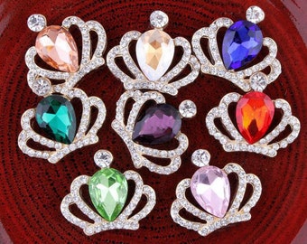 May include: Assortment of eight rhinestone crown-shaped embellishments with teardrop-shaped crystals in various colors, including pink, green, purple, blue, orange, and peach.