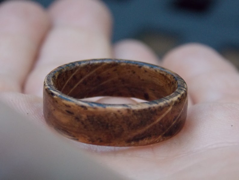 K&ouml;nnte beinhalten: Ein dunkelbrauner Holzring mit nat&uuml;rlicher Holzmaserung.