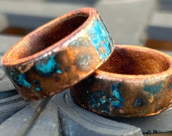 May include: Two wooden rings with copper and turquoise inlay. The rings are stacked on top of each other.
