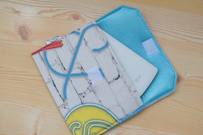 K&ouml;nnte beinhalten: Ein wei&szlig;es Tablet-Computer mit einer blauen und wei&szlig;en Ziegelmusterh&uuml;lle. Die H&uuml;lle hat ein blaues Neon-Design und ein rotes und wei&szlig;es Etikett mit der Aufschrift "Recycled with love".