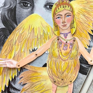 May include: A paper doll of a winged figure with a yellow feathered body, arms, and wings. The doll has a crown, jewelry, and bird-like feet. The background features a black and white illustration of a woman's face.