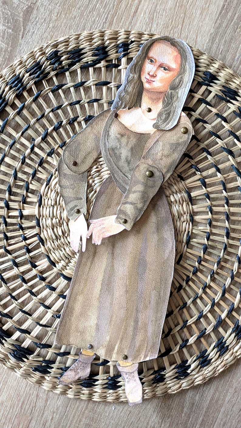 May include: A paper doll of the Mona Lisa, with articulated arms and legs, is set against a woven basket background. The doll is dressed in a brown gown and has a serene expression. The basket has a circular design.