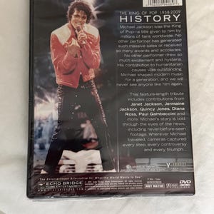 May include: A DVD case for the documentary Michael Jackson: The King of Pop 1958-2009 History. The back cover features a photograph of Michael Jackson in a red jacket and black pants, along with biographical text, a barcode, and technical specifications.