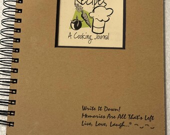 May include: A spiral-bound cooking journal with a kraft paper cover. The cover features a framed illustration with the word "Recipes" and a chef's hat. Below the illustration is the text "A Cooking Journal". The bottom of the cover has the text "Write It Down! Memories Are All That's Left Live, Love, Laugh..."