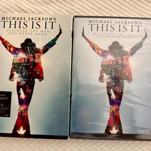 May include: Two DVD cases for Michael Jackson's This Is It, featuring a silhouette of a performer with arms raised against a light blue background. The cover text reads Michael Jackson's This Is It, Discover The Man You Never Knew.