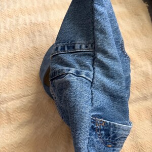 May include: A blue denim hat with a curved brim and a small pocket detail. The hat is made of a classic blue denim material and features visible stitching.