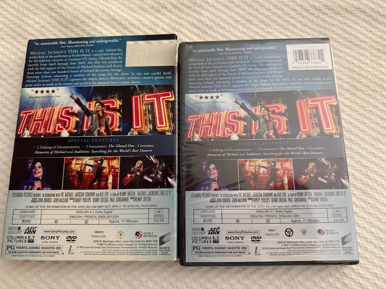 May include: Two identical DVD cases for Michael Jackson's This Is It. The back covers feature the film title in large red neon-style letters, images of the performer, and text detailing special features, technical specifications, and production credits.