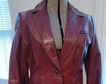 May include: A burgundy leather blazer with a single button closure and two front pockets.