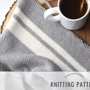 May include: Knitting pattern for a striped baby blanket in gray and white yarn. The pattern is called "Cluck Cluck Boots".