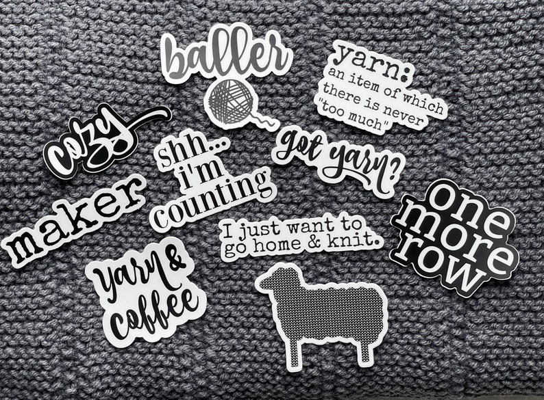 May include: A collection of ten white and black stickers with various knitting and yarn-themed sayings. The stickers include phrases like "cozy maker", "yarn & coffee", "one more row", "got yarn?" and "I just want to go home & knit".