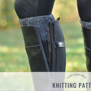 Puede incluir: Un par de botas de cuero negro con una cremallera en el lateral. Las botas se llevan con polainas de punto grises. El texto "Cluck Cluck Boots Knitting Pattern" está impreso sobre un fondo blanco.
