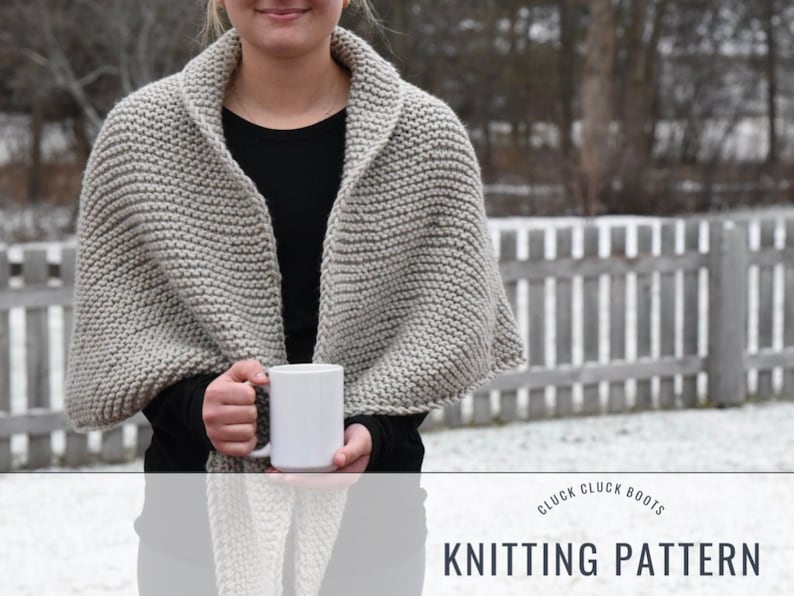 May include: A gray knitted shawl with a simple stitch pattern. The shawl is draped over a person's shoulders and they are holding a white mug. The image has the text "Cluck Cluck Boots Knitting Pattern" at the bottom.