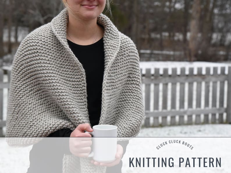 May include: A gray knitted shawl with a cowl neck, worn by a person holding a white mug. The text "Cluck Cluck Boots Knitting Pattern" is at the bottom of the image.