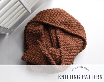 May include: A brown knitted scarf with a textured stitch pattern. The scarf is folded and arranged on a white surface. The text "CLUCK CLUCK BOOTS KNITTING PATTERN" is printed below the scarf.