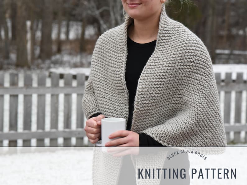 May include: A person wearing a gray knitted shawl with a black shirt and holding a white mug. The text "Cluck Cluck Boots Knitting Pattern" is at the bottom of the image.