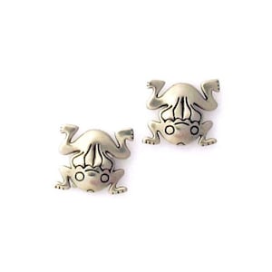 May include: A pair of silver frog earrings. The frogs are facing upwards with their legs outstretched.