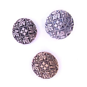 May include: Three silver-toned buttons with a leaf pattern. Each button has a different arrangement of leaves.