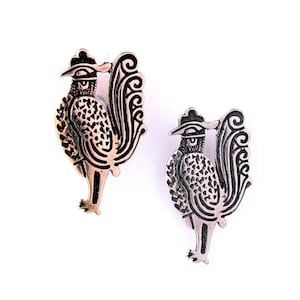 May include: A pair of silver rooster earrings with black detailing. The roosters are stylized and have a detailed design.