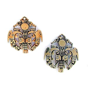 May include: Two gold-toned pendants featuring a stylized design of two birds flanking a central structure. The pendants are detailed with intricate carvings and patterns.