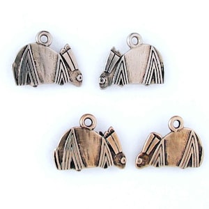 May include: Four silver and copper-toned charms shaped like stylized bats. The charms have a loop at the top for attaching to a necklace or bracelet.