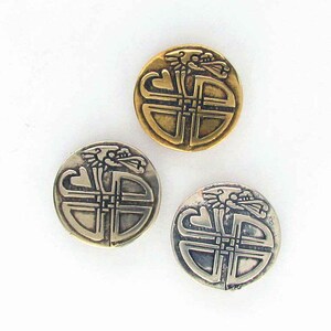 May include: Three round metal buttons with a Celtic knot design and a dragon head at the top. The buttons are in gold, silver, and a combination of gold and silver.